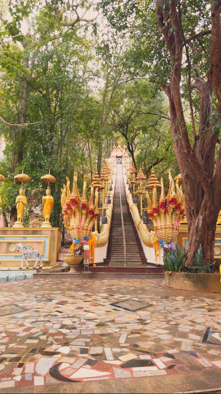 A decorated temple staircase surrounded by trees
